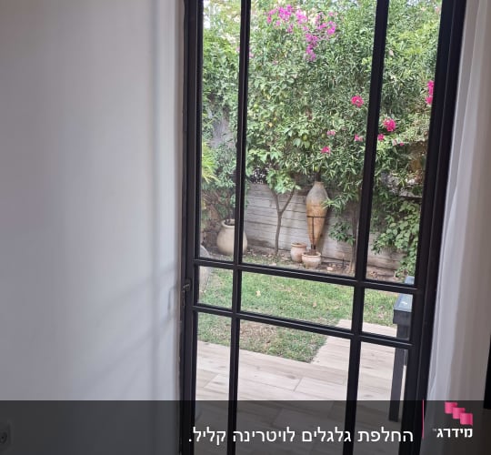 דלת אלומיניום עם חלון המשקיפה לגינה